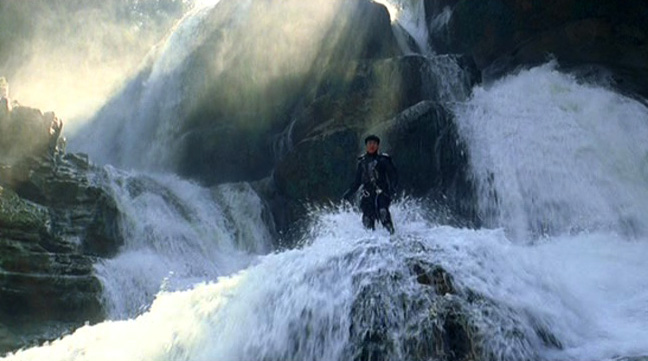 Jackie really does stand in the middle of a raging waterfall