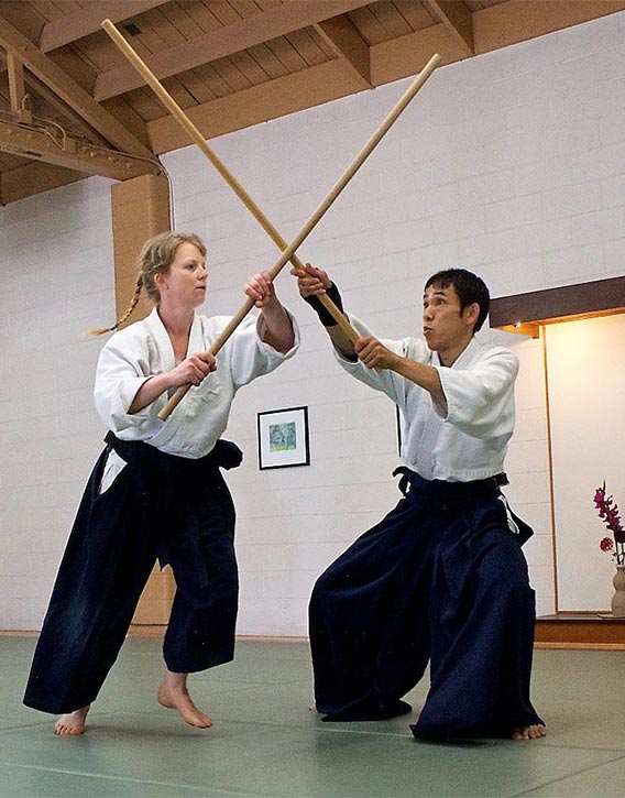 Aikidokas practicing with the Jo staff